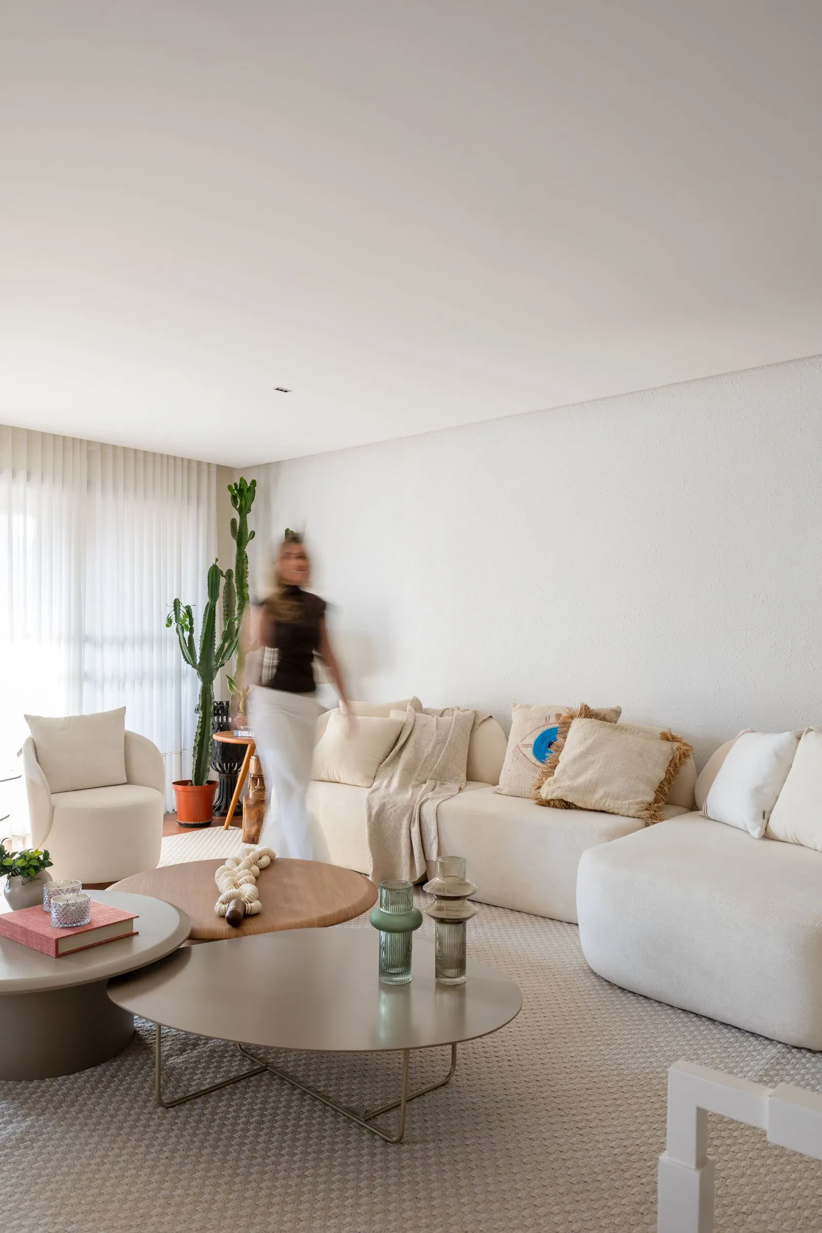 Sala de estar com sofá branco e mesas de centro redondas