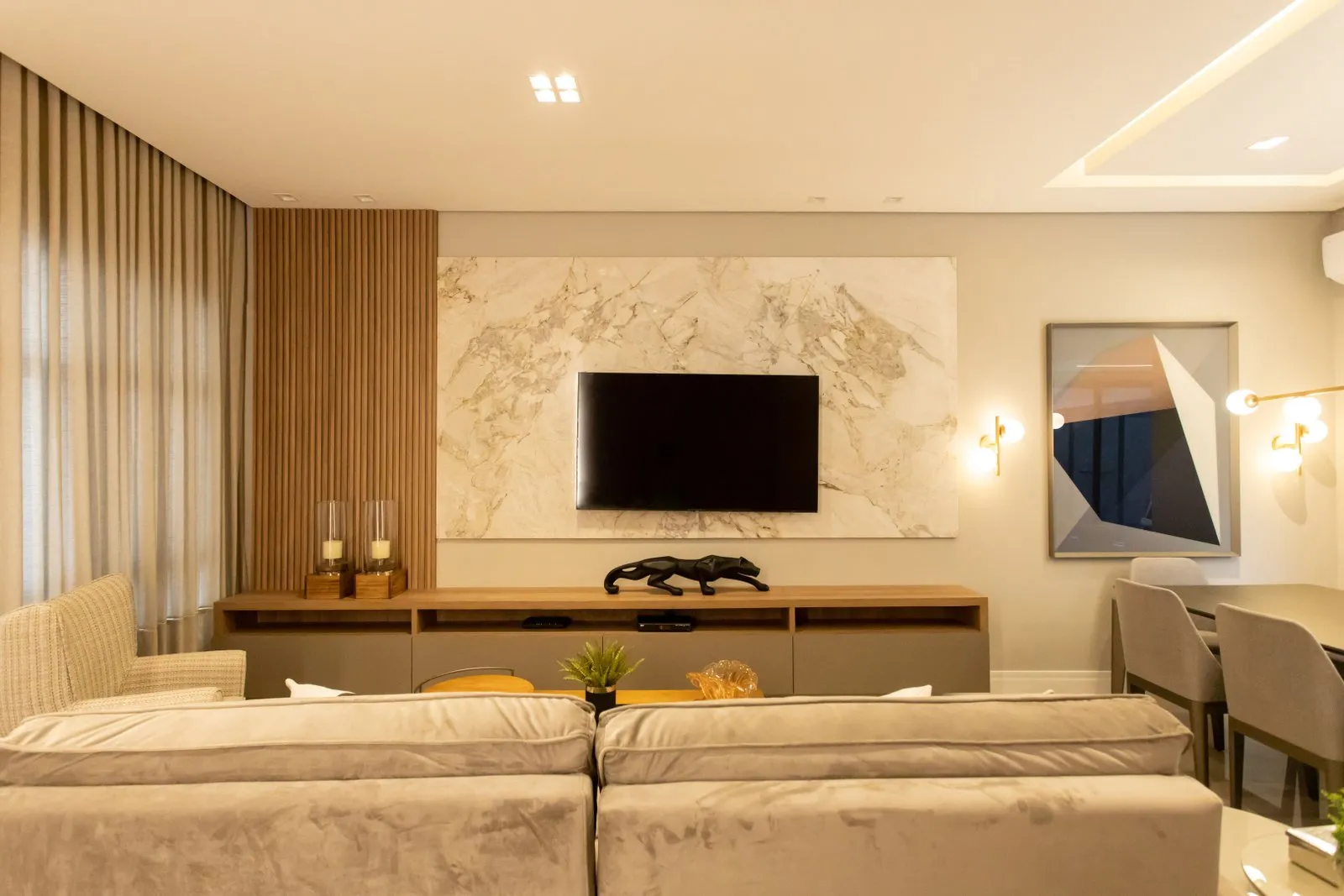 Painel de TV em mármore com rack suspenso e quadro geométrico