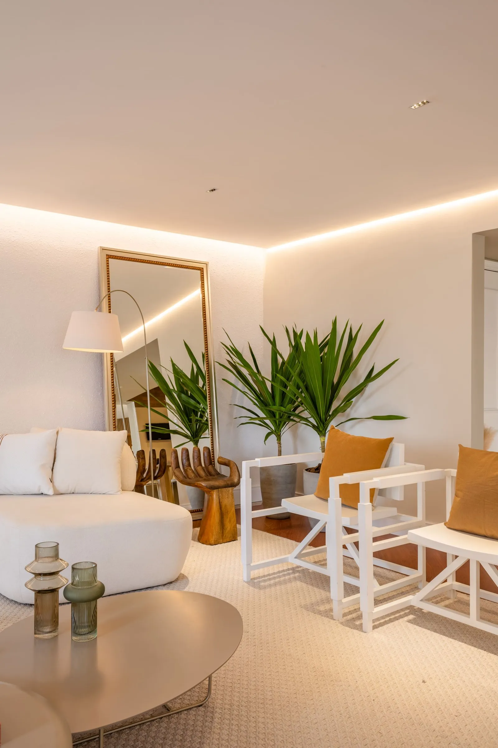 Sala de estar com espelho apoiado na parede e cadeira de madeira