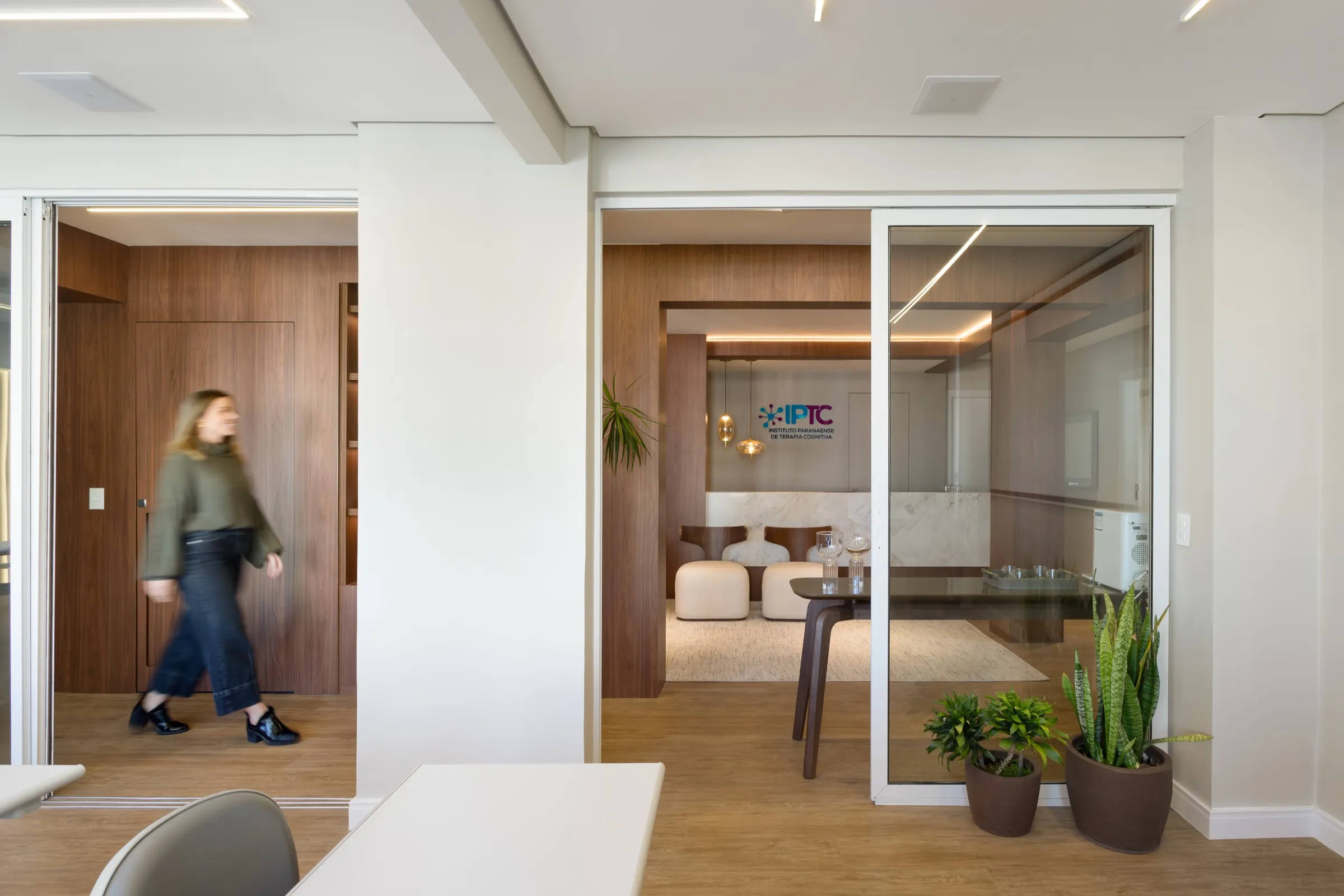Vista através de portas de vidro para recepção e corredor
