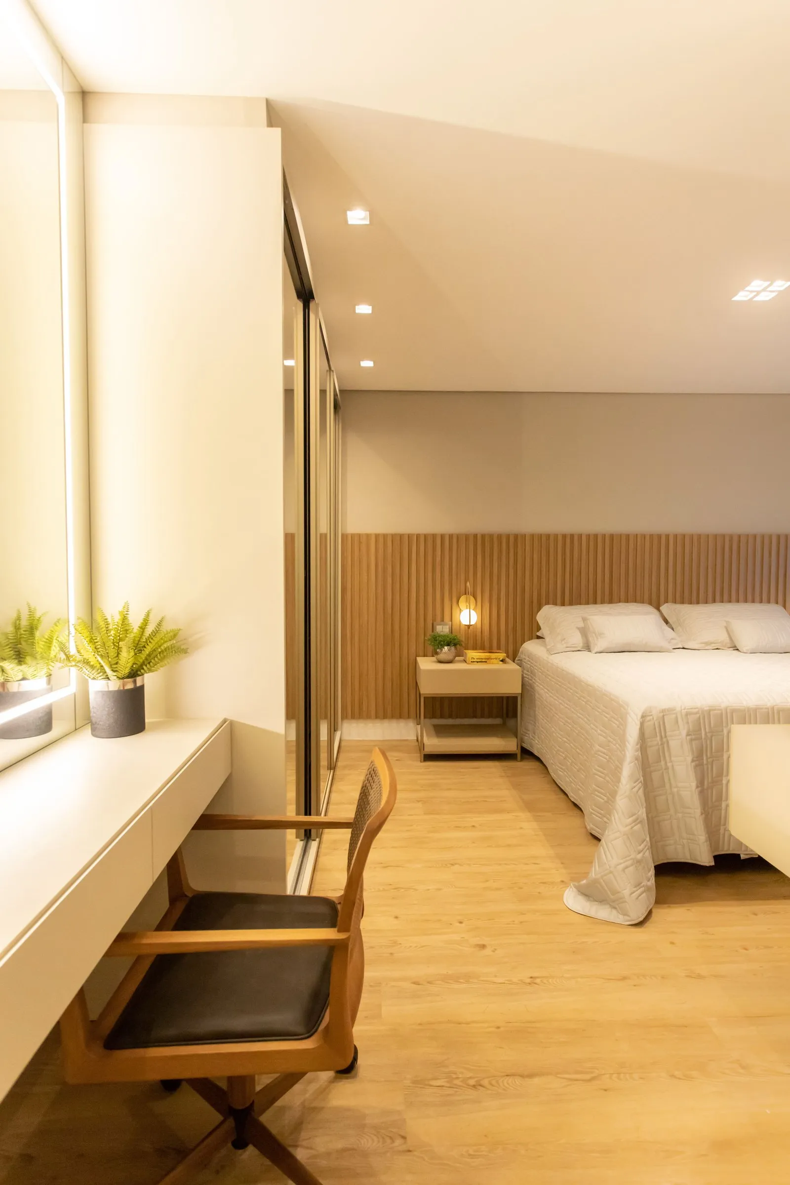 Quarto com painel ripado na cabeceira, mesa de trabalho e luz quente