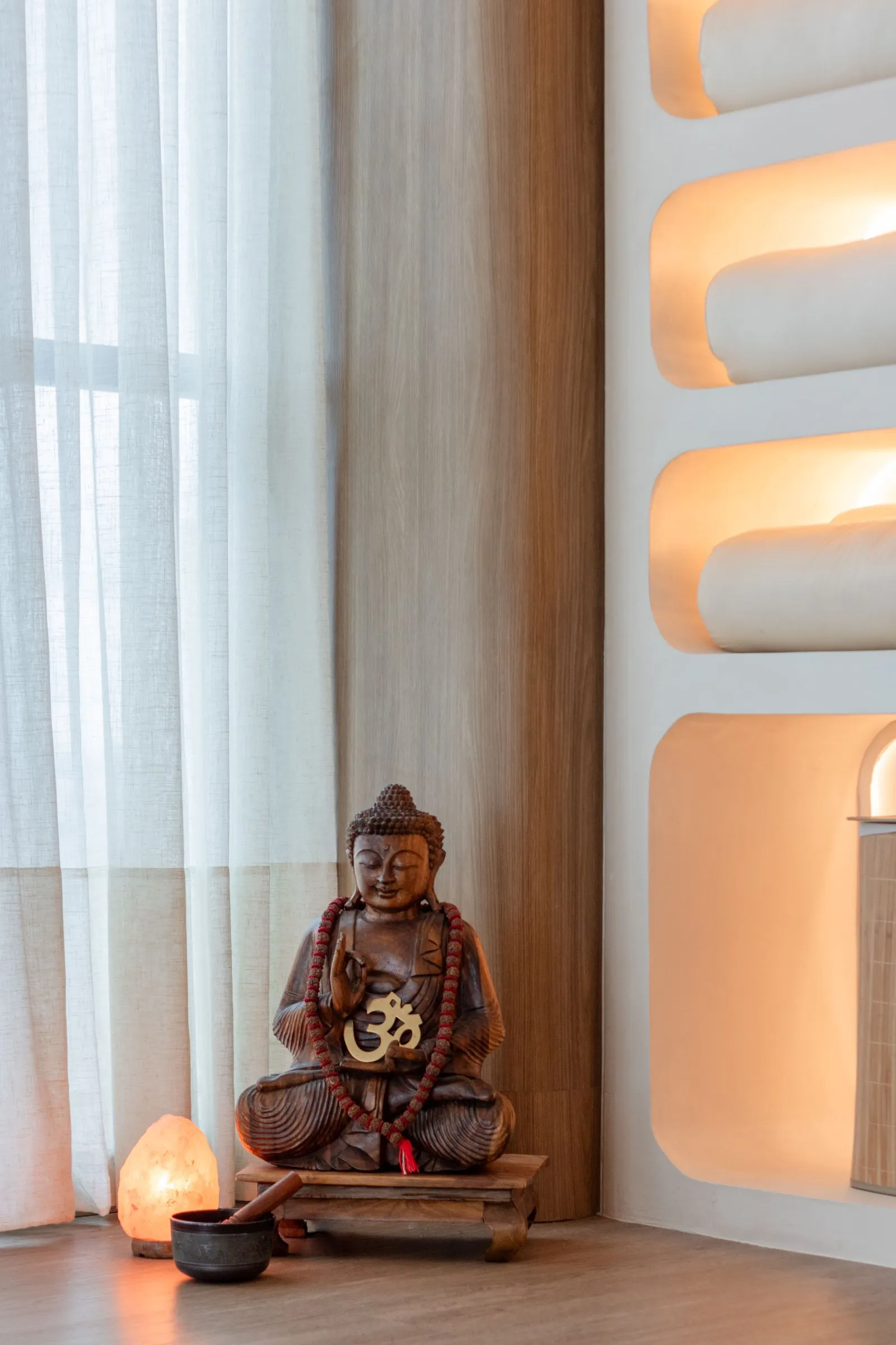 Buda de madeira com lâmpada de sal ao lado de nichos iluminados