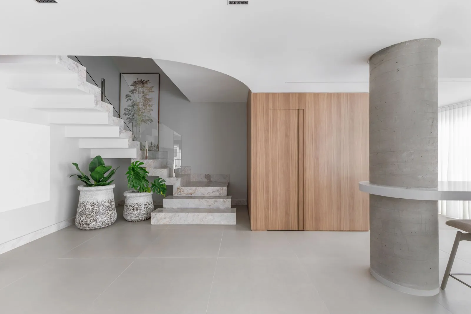 Escada de pedra, vasos com plantas, painel de madeira e pilar de concreto