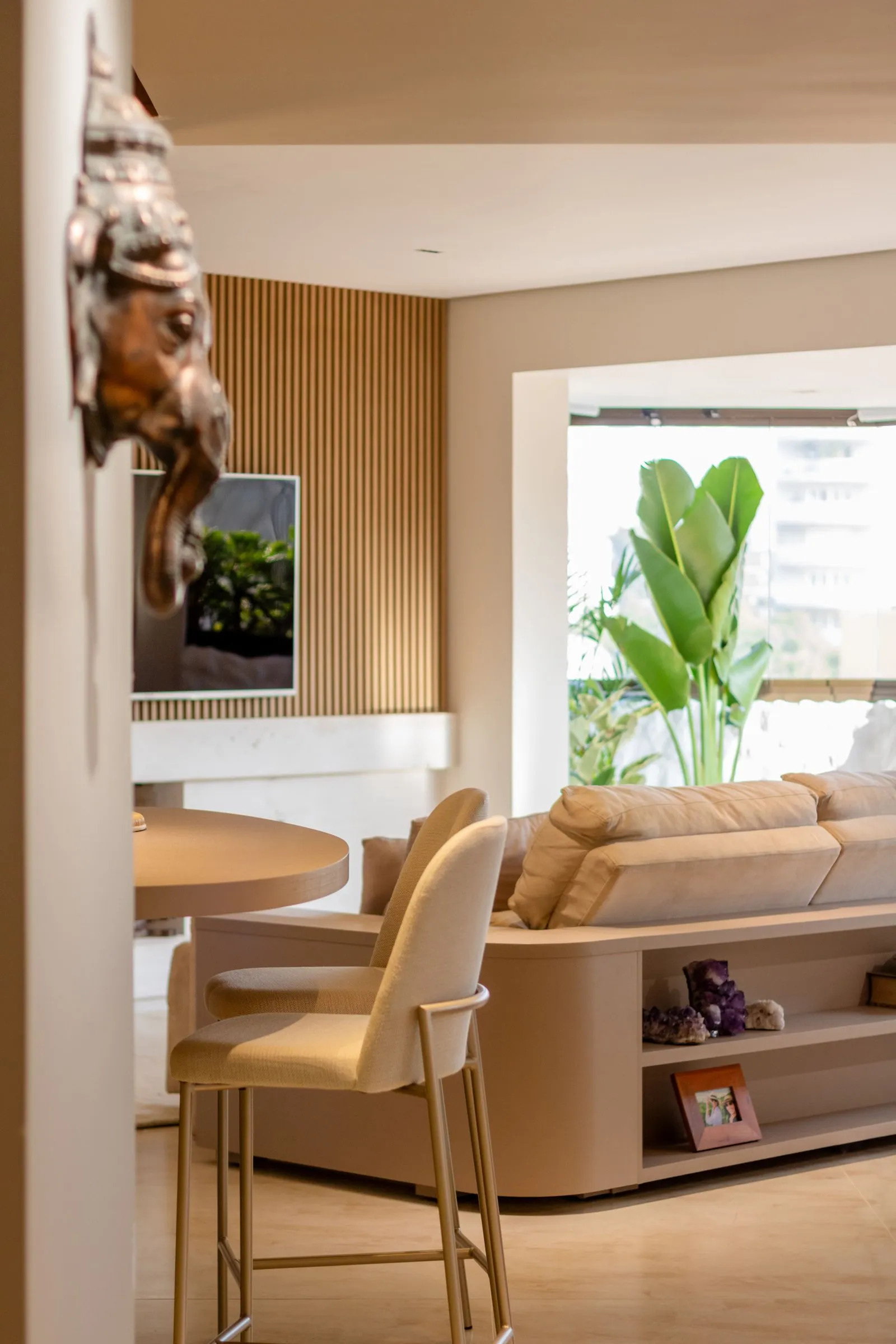 Sala vista da cozinha, com sofá e plantas