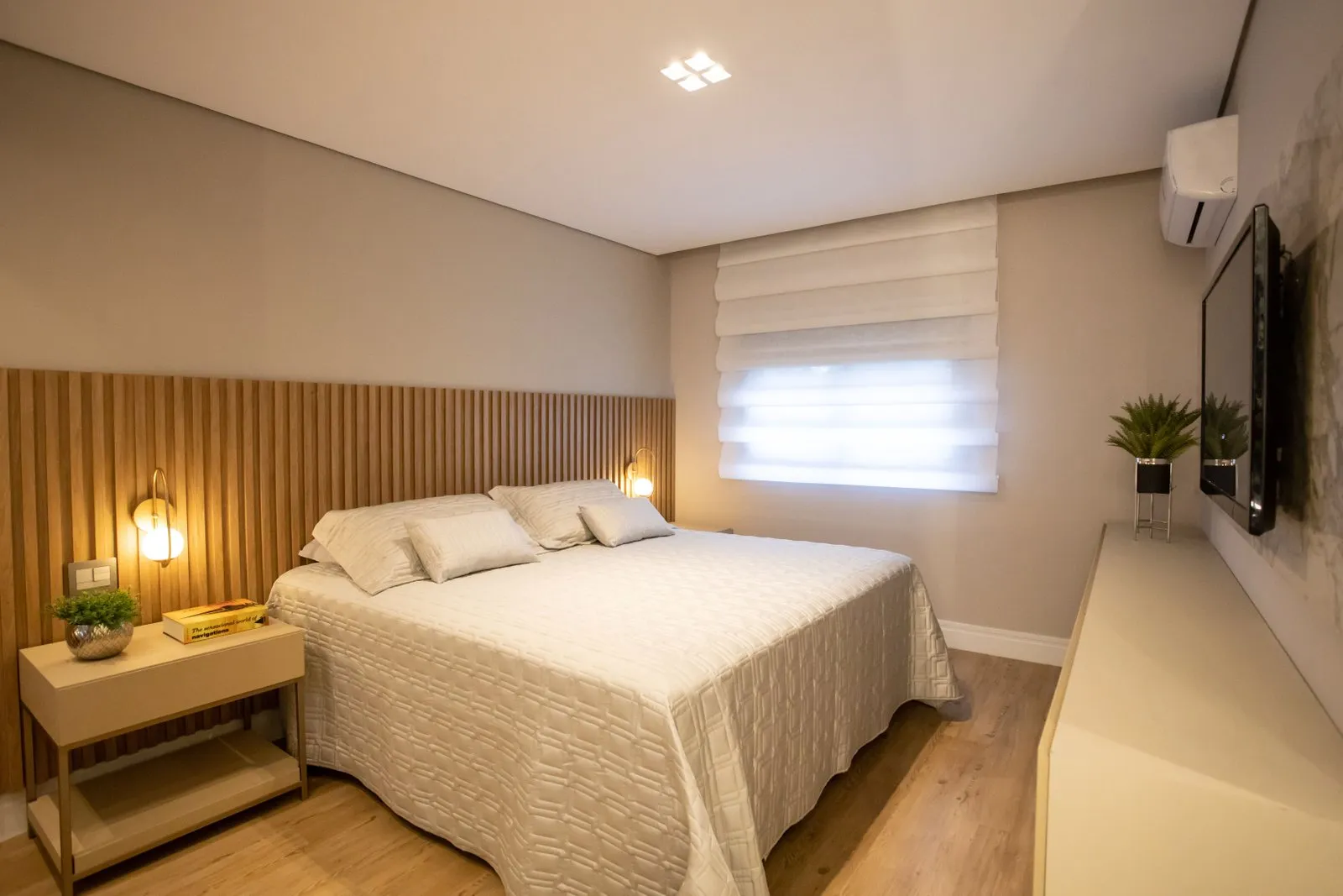 Quarto de casal com cabeceira ripada, arandelas e persiana romana